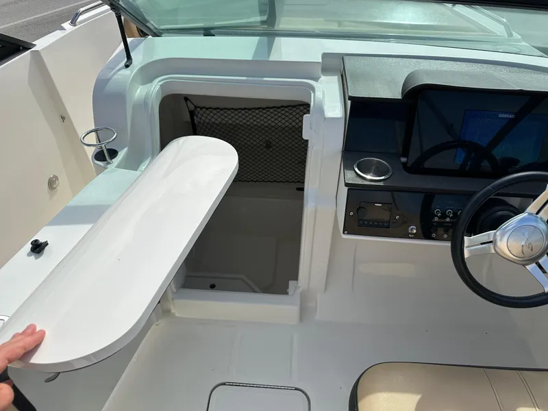 Slide: The Image of 2023 Sea Ray SDX 250 Outboard helm with storage compartment and steering wheel. - 10