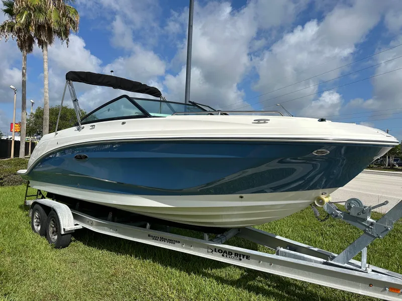 Slide: The Image of 2023 Sea Ray SDX 250 Outboard boat on trailer, parked on grass under blue sky. - 2