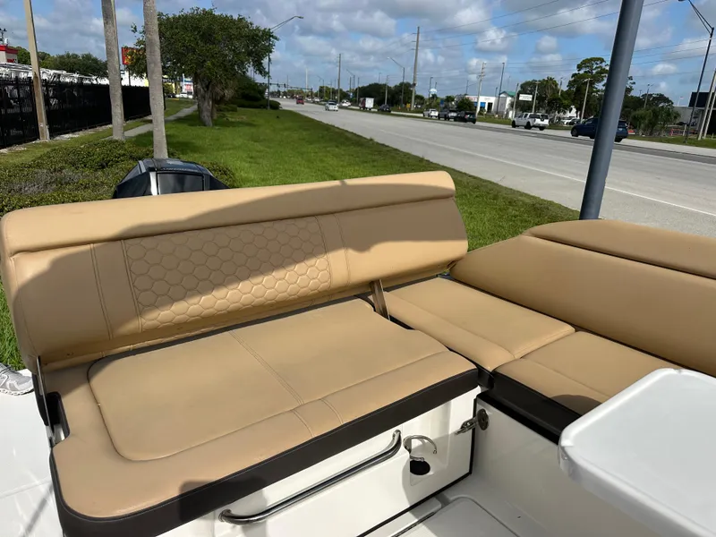 Slide: The Image of 2023 Sea Ray SDX 250 Outboard boat with tan leather seating, parked near a road. - 9