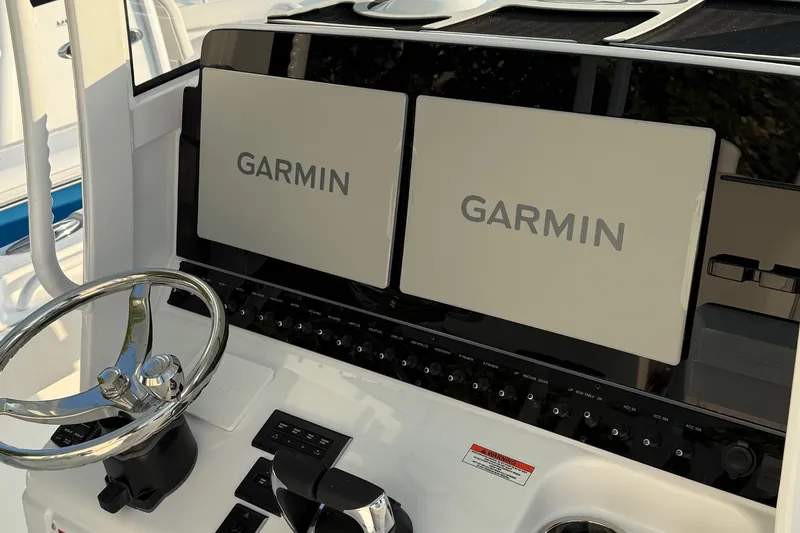 Slide: The Image of 2026 Sea Hunt Gamefish 28 dashboard with dual Garmin displays and steering wheel. - 3