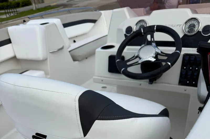 Slide: The Image of 2024 Starcraft SVX 171 OB boat interior with steering wheel and white seating. - 6