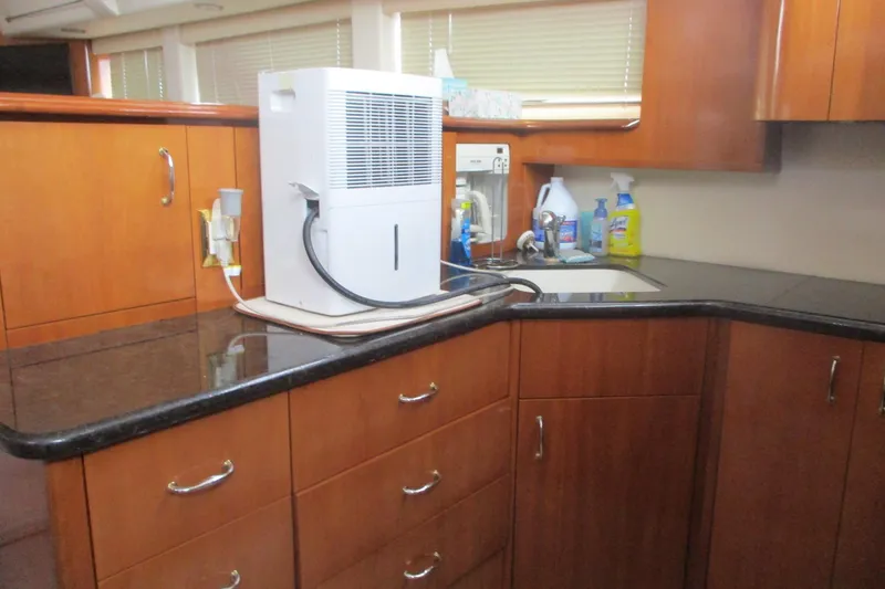 Slide: The Image of 2006 Carver 466 Motor Yacht kitchen with wooden cabinets and countertop appliances. - 39