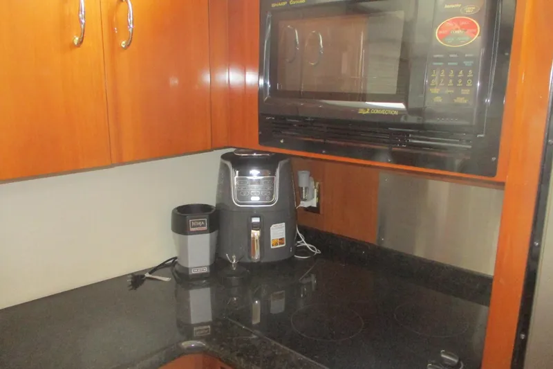 Slide: The Image of Kitchen area of 2006 Carver 466 Motor Yacht with appliances and wooden cabinets. - 40