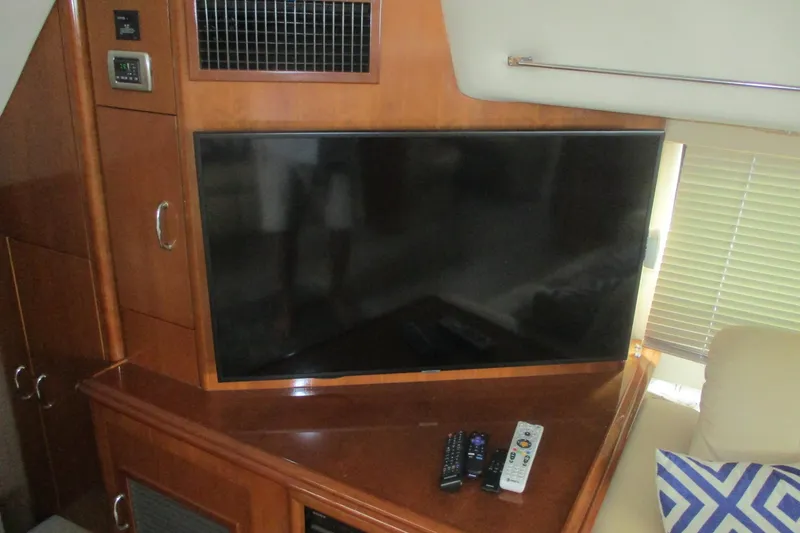 Slide: The Image of Flat-screen TV and remotes in 2006 Carver 466 Motor Yacht interior. - 49