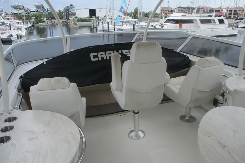 Slide: The Image of 2006 Carver 466 Motor Yacht interior with white seating and marina view. - 6
