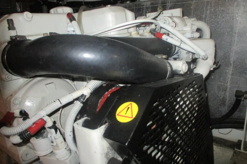 Slide: The Image of Engine compartment of a 2006 Carver 466 Motor Yacht, featuring hoses and warning label. - 66