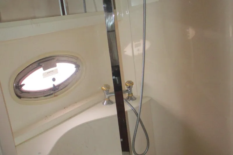 Slide: The Image of Shower area in 2006 Carver 466 Motor Yacht with oval window and chrome fixtures. - 56