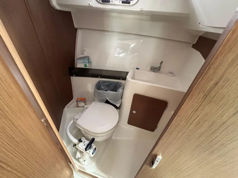 Slide: The Image of 2019 Jeanneau NC 795 boat bathroom with toilet, sink, and wooden accents. - 11