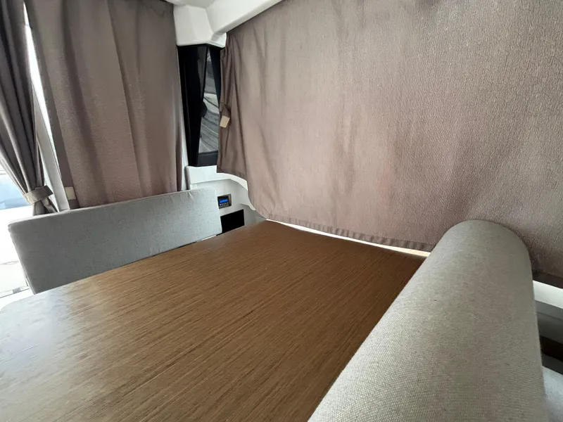 Slide: The Image of Interior of 2019 Jeanneau NC 795 boat with wooden table and gray seating. - 12