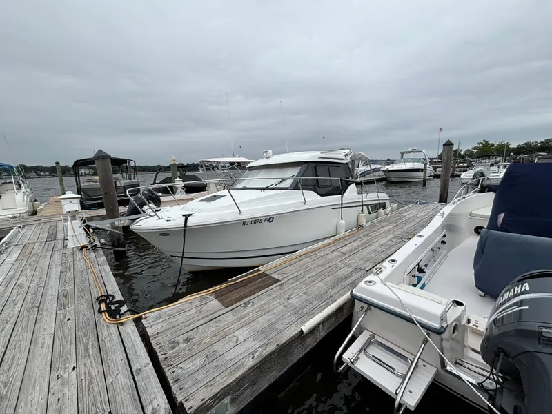 Slide: The Image of 2019 Jeanneau NC 795 boat docked at a marina under cloudy skies. - 5