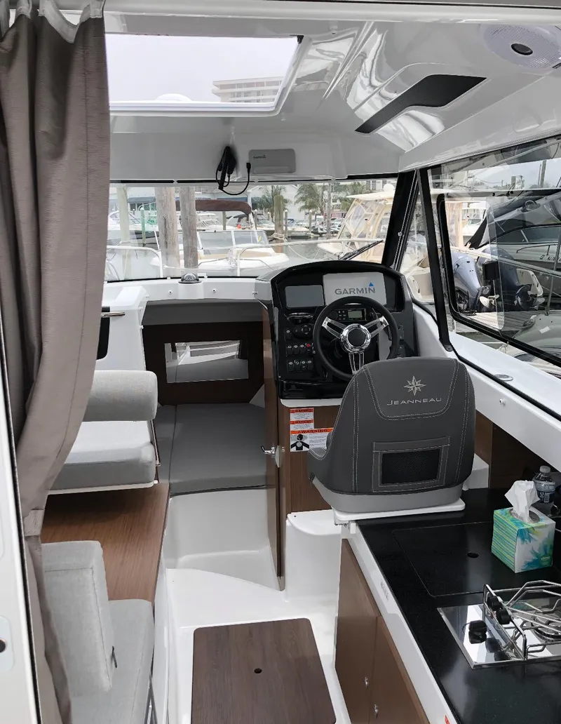 Slide: The Image of Interior of 2019 Jeanneau NC 795 boat with steering wheel and seating area. - 8
