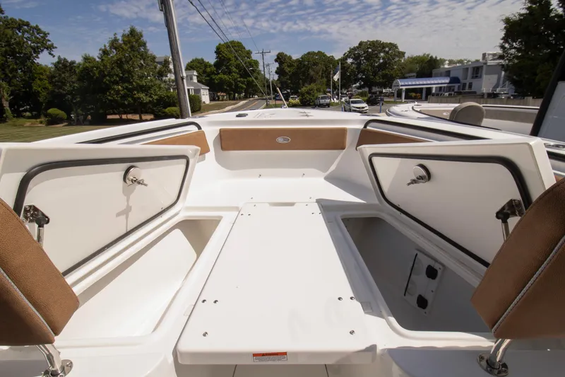 Slide: The Image of 2026 Sea Hunt Ultra 265 SE boat interior with open storage compartments, under a clear sky. - 3