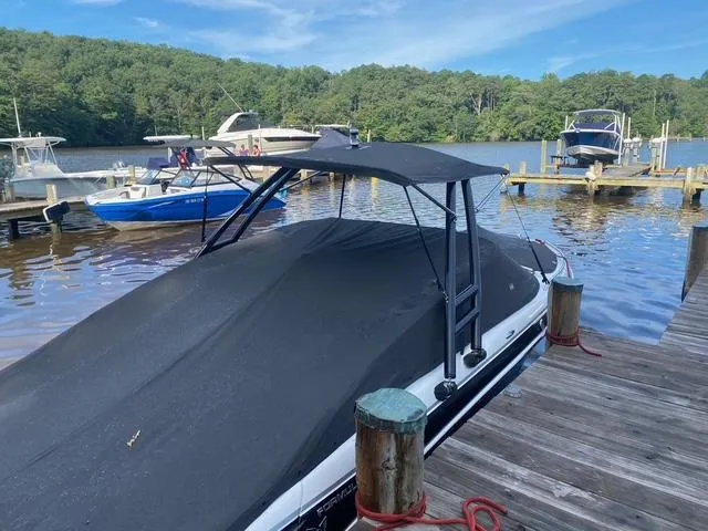 Slide: The Image of 2006 Formula 240 Bowrider boat docked with cover, surrounded by serene lake and forest. - 10