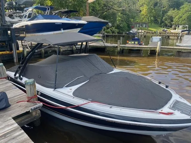 Slide: The Image of 2006 Formula 240 Bowrider boat docked with cover, surrounded by other boats and greenery. - 11