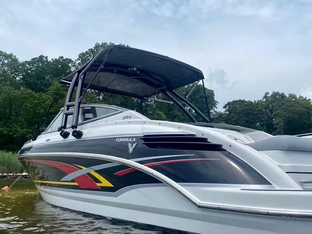 Slide: The Image of 2006 Formula 240 Bowrider boat with sleek design and vibrant graphics on a calm lake. - 13