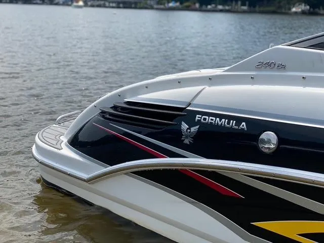Slide: The Image of 2006 Formula 240 Bowrider boat on calm water, showcasing sleek design and branding. - 14