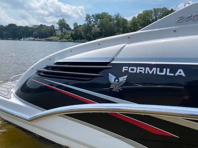Slide: The Image of 2006 Formula 240 Bowrider boat on a lake, sleek design with logo and red accents. - 15
