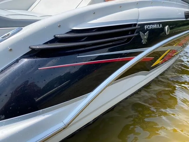 Slide: The Image of 2006 Formula 240 Bowrider boat with sleek design and vibrant graphics on the water. - 16