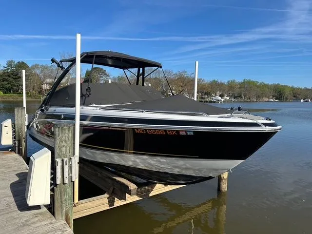 Slide: The Image of 2006 Formula 240 Bowrider boat docked on a lift by a serene lake. - 18