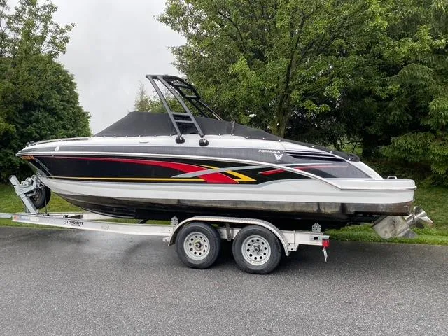 Slide: The Image of 2006 Formula 240 Bowrider boat on trailer, parked outdoors near trees. - 3