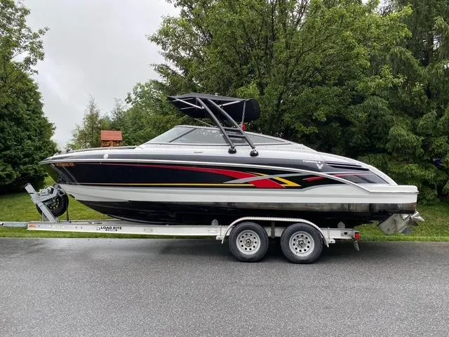 Slide: The Image of 2006 Formula 240 Bowrider boat on trailer, black with red accents, parked on a road. - 31
