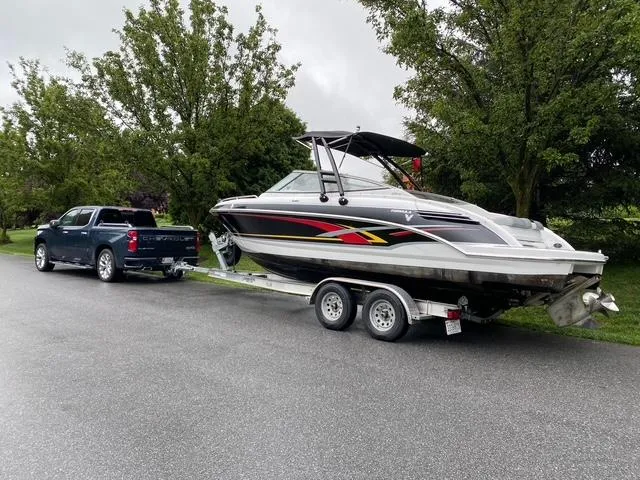 Slide: The Image of 2006 Formula 240 Bowrider boat on trailer, towed by a truck, parked on a tree-lined street. - 32