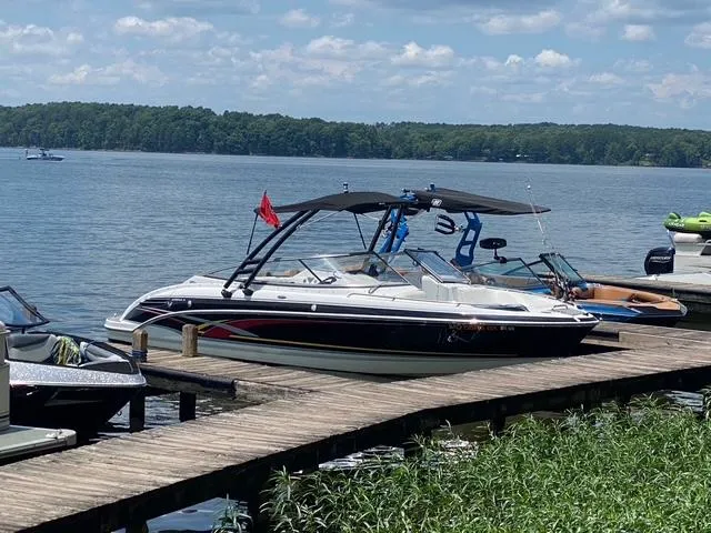 Slide: The Image of 2006 Formula 240 Bowrider docked on a sunny lake with lush greenery. - 8