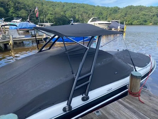 Slide: The Image of 2006 Formula 240 Bowrider boat docked with black cover and canopy on a serene lake. - 9
