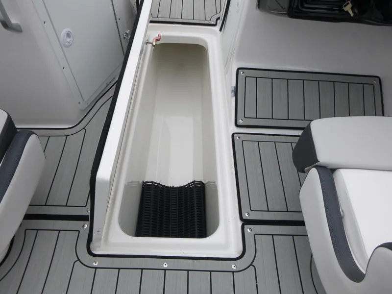 Slide: The Image of 2025 Yamaha Boats 195S interior storage compartment with sleek, modern design and gray flooring. - 12
