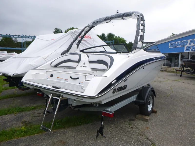 Slide: The Image of 2025 Yamaha Boats 195S on trailer, white exterior, parked outdoors. - 3