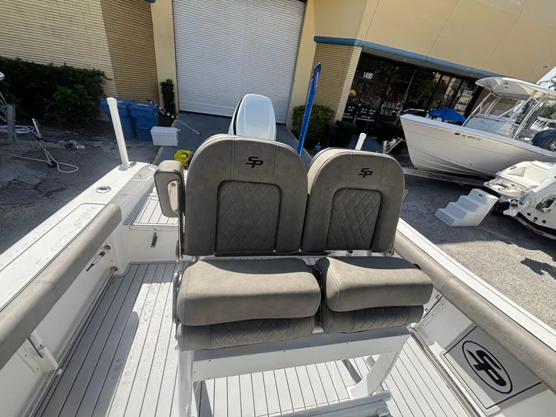 Slide: The Image of 2022 Sea Pro 239 Center Console boat with dual cushioned seats, docked outdoors. - 16