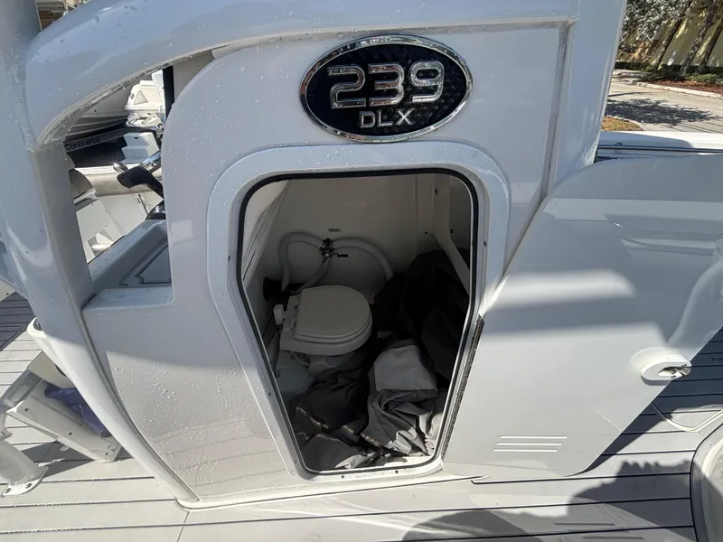 Slide: The Image of 2022 Sea Pro 239 Center Console boat with open storage compartment and visible toilet. - 17