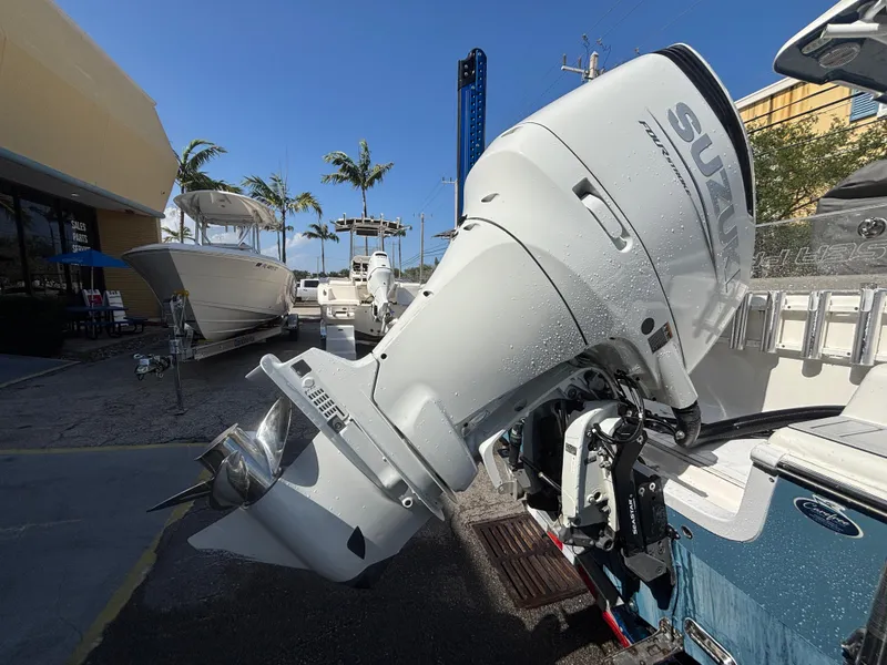Slide: The Image of 2022 Sea Pro 239 Center Console with Suzuki outboard motor, docked under clear blue sky. - 6