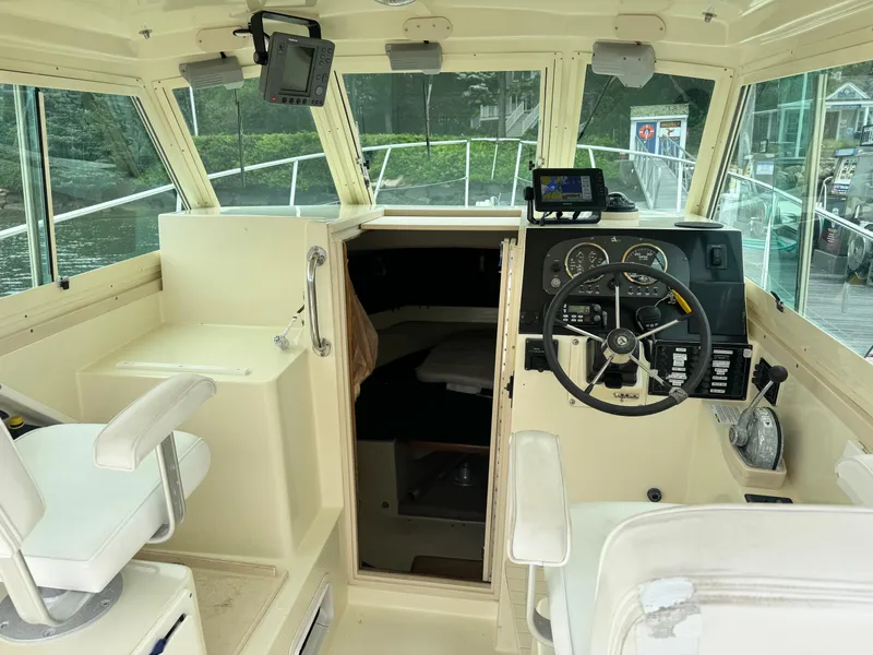 Slide: The Image of 2001 Albin 28 boat interior with steering wheel, navigation equipment, and seating. - 10