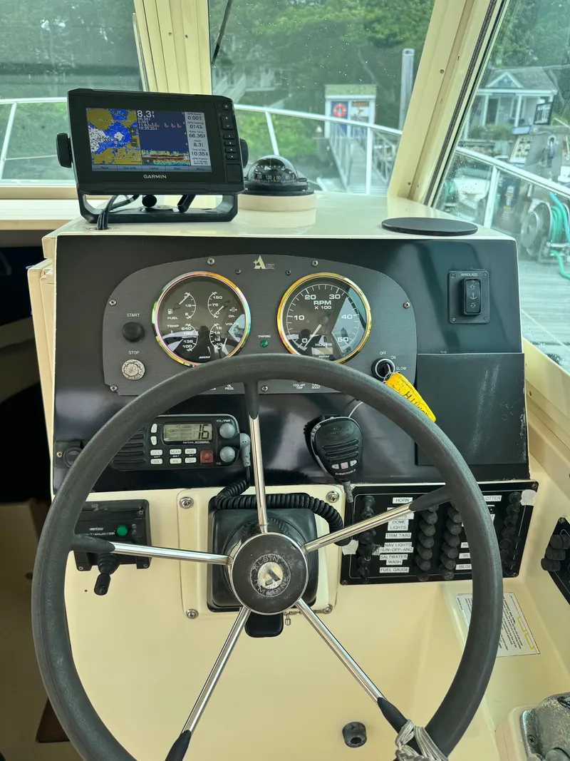 Slide: The Image of Steering wheel and dashboard of a 2001 Albin 28 boat with navigation equipment. - 11
