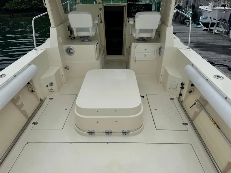 Slide: The Image of 2001 Albin 28 boat interior with seating and storage, docked by the water. - 12