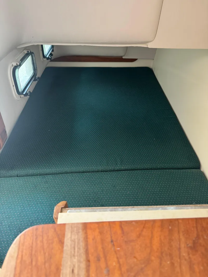 Slide: The Image of Interior cabin of a 2001 Albin 28 boat with green cushioned seating. - 13