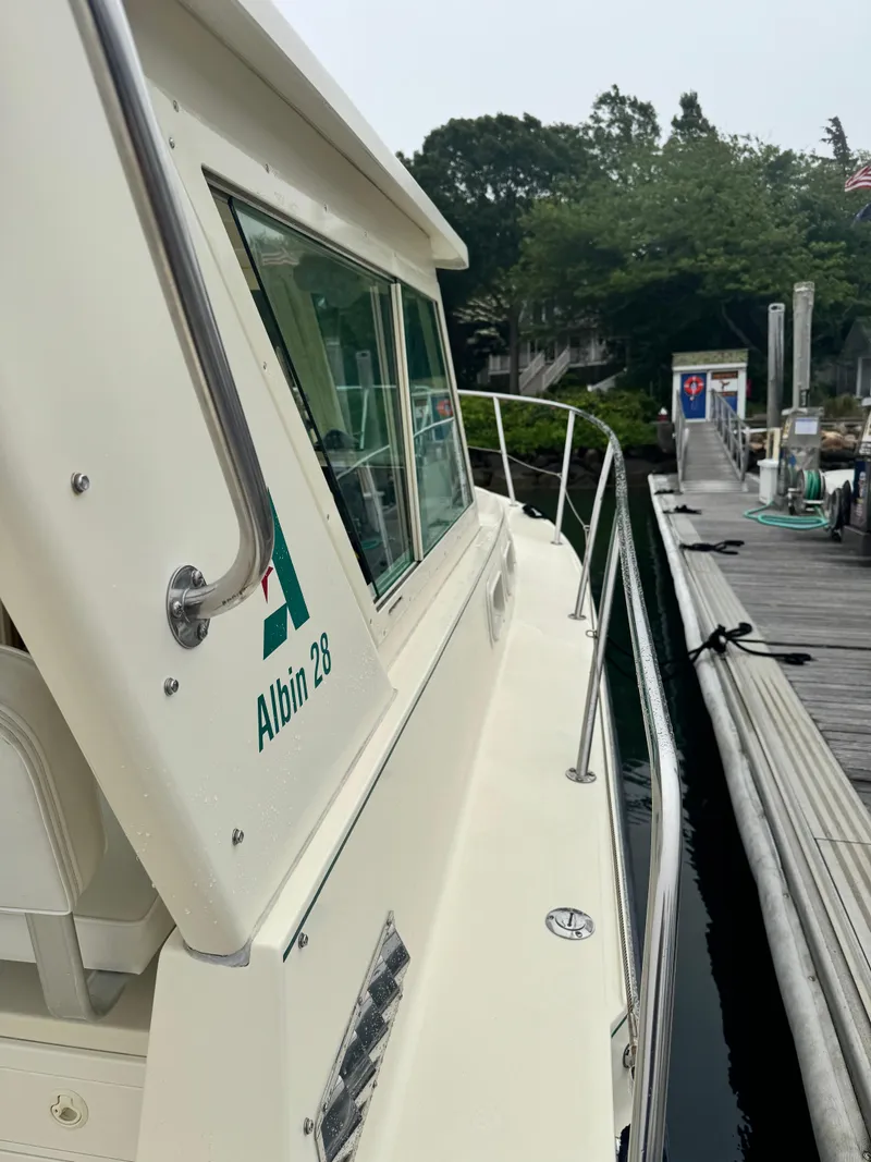 Slide: The Image of 2001 Albin 28 boat docked at a marina, featuring sleek design and railing. - 6