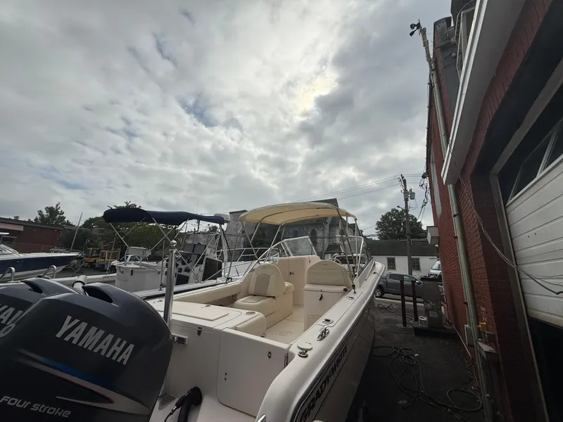 Slide: The Image of 2007 Grady-White Tournament 275 boat with Yamaha engines, docked near a brick building under cloudy skies. - 3