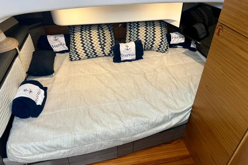 Slide: The Image of Cozy cabin interior of 2020 Tiara Yachts 43 LS with patterned pillows and branded towels. - 17