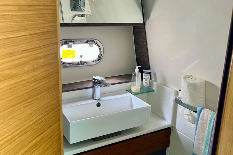 Slide: The Image of Modern bathroom in 2020 Tiara Yachts 43 LS, featuring sink, mirror, and porthole window. - 19