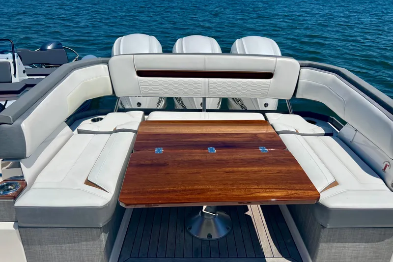 Slide: The Image of 2020 Tiara Yachts 43 LS luxury seating area with wooden table on water. - 7
