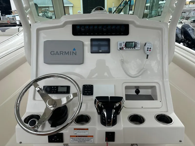 Slide: The Image of 2023 Sailfish 272 CC boat interior with windshield and control panel at marina. - 12