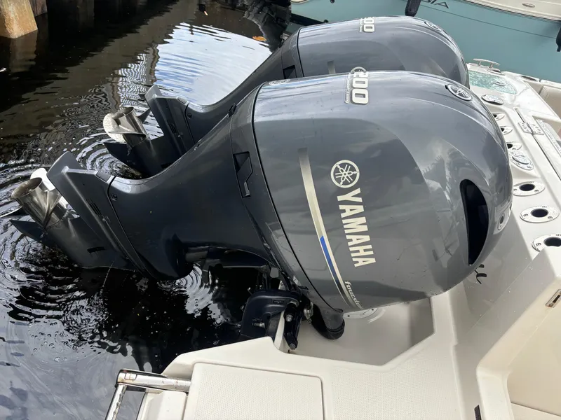 Slide: The Image of 2023 Sailfish 272 CC boat with dual Yamaha engines docked at a marina. - 7