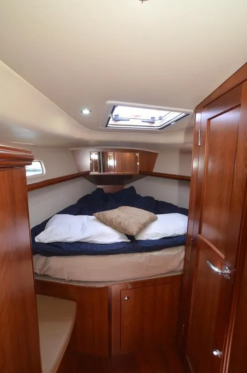 Slide: The Image of 2016 Marlow-Hunter 40 yacht cabin with cozy bed and wooden interior. - 19