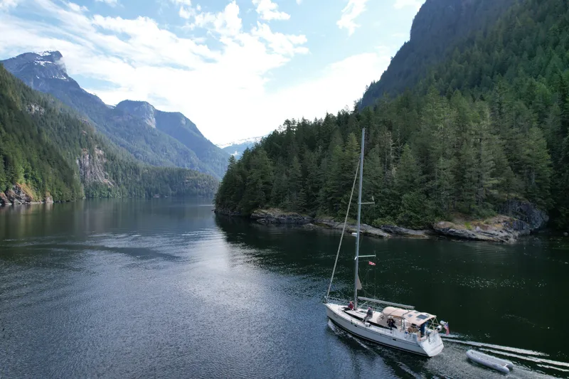 Slide: The Image of Sailboat Marlow-Hunter 40 (2016) cruising through scenic forested mountain fjord. - 2