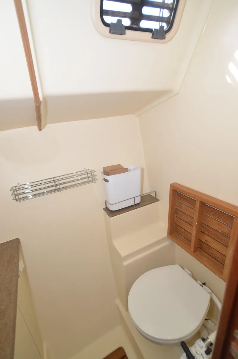 Slide: The Image of 2016 Marlow-Hunter 40 yacht bathroom with toilet, storage, and ventilation window. - 27