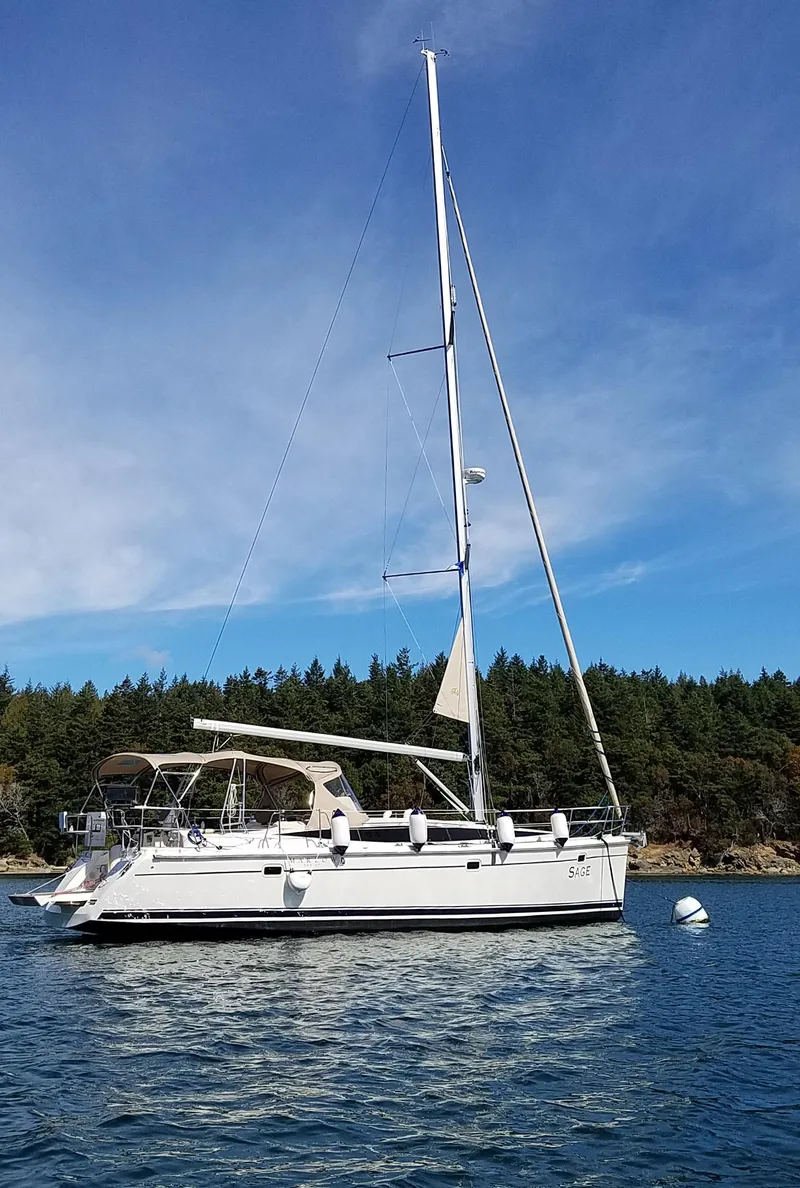 Slide: The Image of 2016 Marlow-Hunter 40 sailboat anchored on calm water with forested shoreline. - 4
