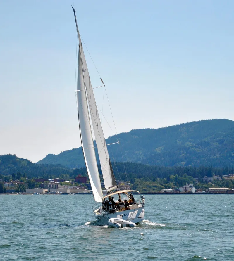 Slide: The Image of 2016 Marlow-Hunter 40 sailboat navigating scenic waters with mountainous backdrop. - 6
