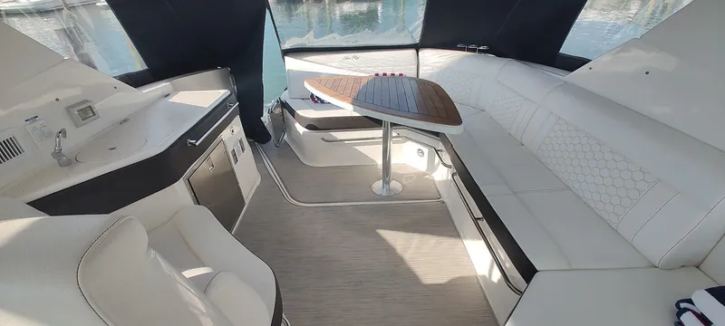 Slide: The Image of Interior of 2021 Sea Ray Sundancer 320 yacht with white seating and wooden table. - 11